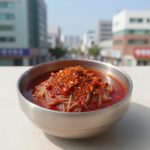 비빔냉면 양념장 완성 사진, 고춧가루와 과일이 섞인 붉은 양념장이 그릇에 담겨 있다