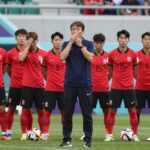 한국 축구 대표팀이 남아공전 패배 후 실망한 표정으로 그라운드를 바라보고 있다. 홍명보 감독의 무기력한 지휘와 함께 32강 탈락의 아쉬움이 느껴진다.