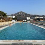 공주 채온재 야외 온수풀 전경, 계룡산을 배경으로 길게 뻗은 수영장