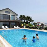 제주도 펜션 수영장 독채 풀빌라에서 가족이 물놀이를 즐기는 모습