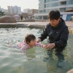 오션월드 겨울 실내 유수풀에서 아이와 함께 둥둥 떠 있는 모습, 따뜻한 물과 차가운 공기의 대비가 느껴지는 사진