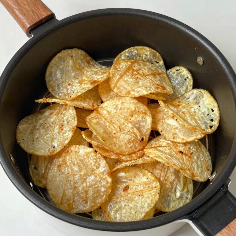 에어프라이어 바스켓에 겹치지 않게 펼쳐진 얇게 썬 감자칩 조리 전 모습