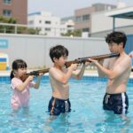 전동 물총 너프건을 들고 신나게 물놀이하는 아이들과 가족
